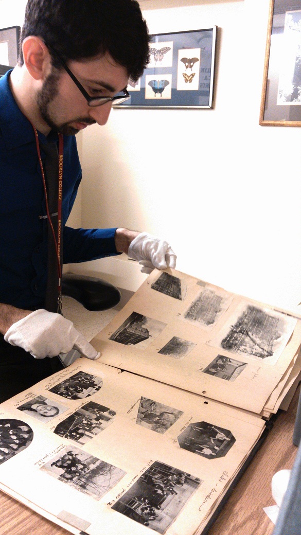 Project Archivist Steven Calco looking at a disbound 1930s photo scrapbook of Brooklyn YWCA Branch activities.